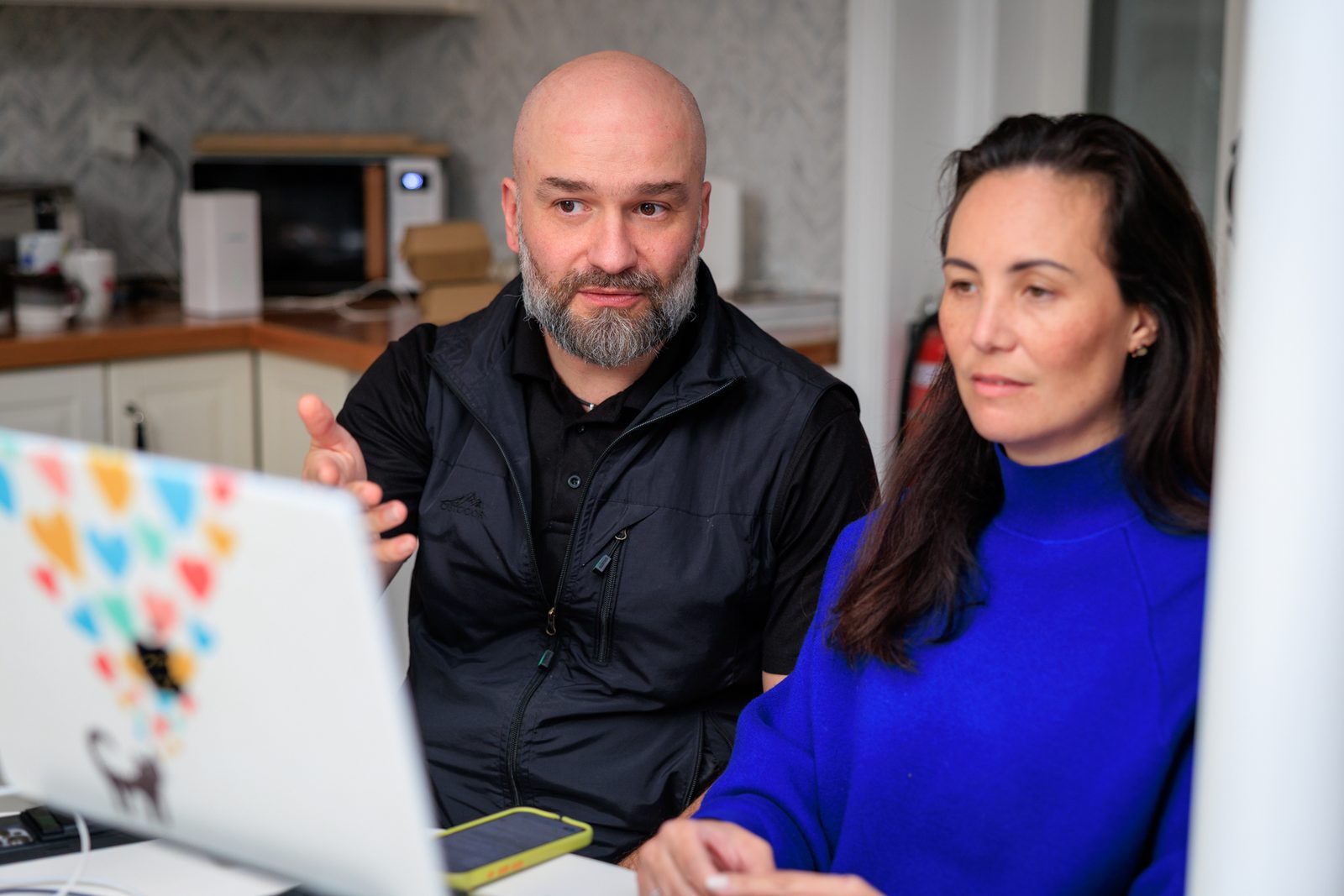 Arek Rainczuk working through a build at a laptop alongside another founder